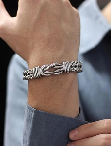 Close-up of a polished stainless steel punk chain bracelet worn on a male wrist