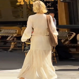 Detail of airy beige chiffon cardigan and tiered ruffle skirt in a French street style