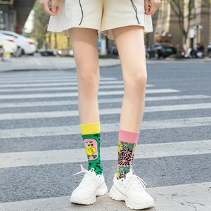 Close-up of asymmetric cotton crew socks with banana and floral patterns on street background