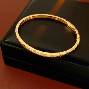 Close-up of golden geometric quilted texture on elegant round metal bangle