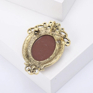 Detail view of the vintage brooch back showing the sturdy gold alloy pin fastener