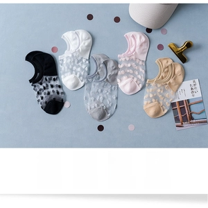 Close-up of five pairs of sheer polka dot no-show socks in various neutral pastel colors
