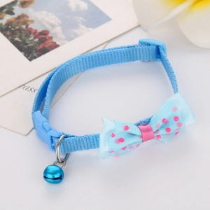 Detail view of light blue polka dot pet collar with bowknot and bell for cats and small dogs