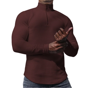 Detail of burgundy waffle knit texture on men's half-zip sweatshirt with stand collar