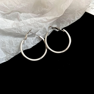 Detail view of silver twisted hoop earrings featuring polished finish and lever-back closure