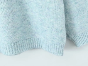 Detail of light blue mohair knit sweater showing ribbed hem and soft fuzzy texture