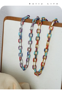 Detail of colorful enamel charms on gold and silver chunky chain necklaces
