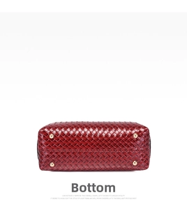 Close-up of woven red leather handbag bottom featuring four protective gold metal feet