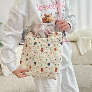 Détail du sac matelassé crème avec imprimé ours et poignées tissées roses