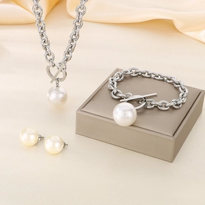 Detailed close-up of pearl jewelry set with OT clasp necklace and bracelet on silk cloth