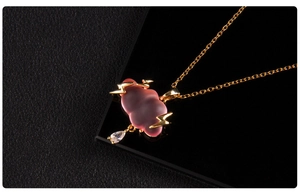 Detail of pink cloud pendant with golden lightning and a crystal teardrop on a gold chain
