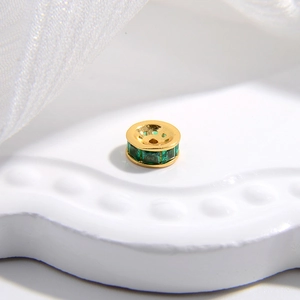 Macro del distanziatore in argento 925 con placcatura dorata e zircone verde intarsiato