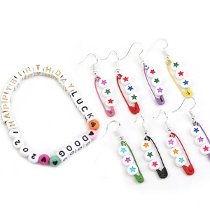 Colorful acrylic letter beads bracelet and safety pin earrings set on white background