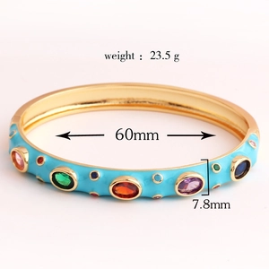 Detail view of gold-plated bangle featuring blue enamel and colorful zircon inlay stones
