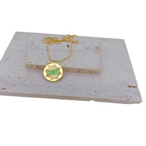 Gold plated evil eye pendant necklace with green zircon inlay on stone pedestal
