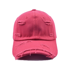 Détail d'une casquette de baseball en toile usée avec bords effilochés rouge foncé