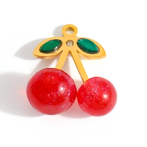 Macro shot of 18K gold-plated cherry pendant with red glitter finish and green leaves