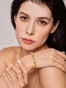 Close-up of 18K gold-plated C-shaped cuff bracelet with white pearls on female wrist