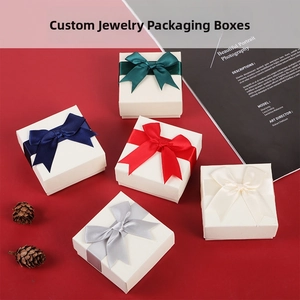 Flat lay of white jewelry gift boxes with satin bows on a stylish red background
