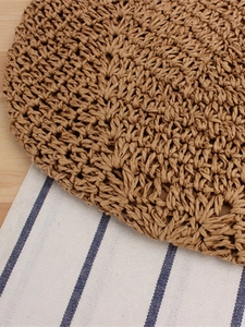 Deep brown hollow woven shoulder bag made of natural paper rope with a boho beach design