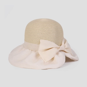 Dettaglio di un cappello da sole a tesa larga ondulata con un grande fiocco elegante