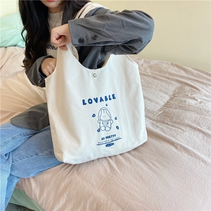 Détail du sac cabas en toile blanche avec motif lapin mignon et bouton pression métal