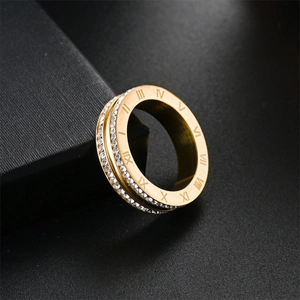 Primer plano de un anillo de acero de titanio dorado con números romanos y piedras