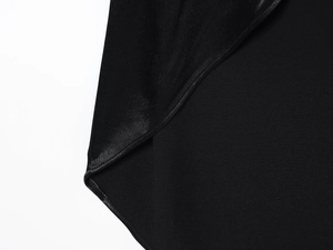 Gros plan d'une chemise noire montrant le contraste entre tissu soyeux et matité