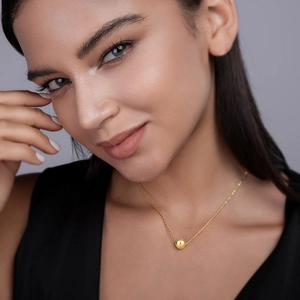 Elegance of S925 sterling silver gold beaded necklace worn by a model on a soft background
