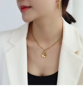Détail d'un collier avec pendentif tulipe dorée et boucles d'oreilles torsadées sur mannequin