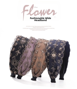 Primer plano de cuatro diademas anchas bordadas con flores y cristales en varios colores
