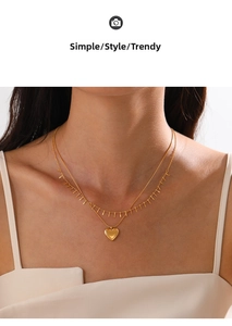 Close-up of double layer 18K gold plated necklace with heart pendant and bar charms
