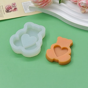 DIY silicone mold for bear and heart shaped cakes, soaps, and candles on a green background