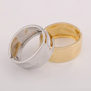 Detail of gold and silver chunky textured metal bangles with polished finish and hinge