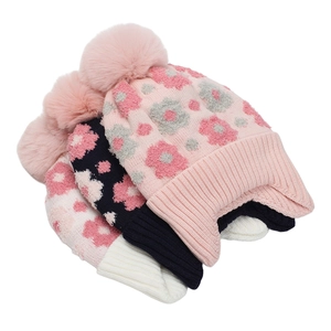 Détail de bonnets en tricot à fleurs avec grands pompons en fausse fourrure et revers