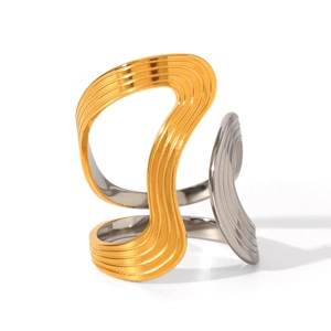 Macro detail of bicolor stainless steel ring with elegant wavy texture and golden finish