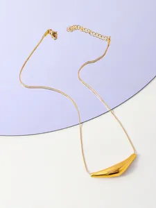 Gros plan du pendentif géométrique doré avec chaîne serpent et fermoir mousqueton