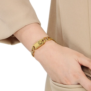 Gros plan d'un bracelet gourmette doré avec boucle mécanique sur le poignet d'un homme