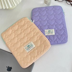 Detail of heart-quilted iPad and laptop sleeves in soft pink and lilac purple colors