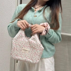 Close-up of a floral lunch bag with pink flower patterns and brand label for daily use