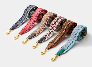 Set of six colorful woven shoulder straps with leather ends and gold metal buckles