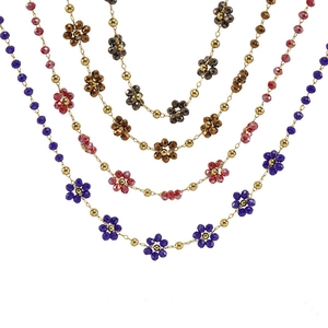 Detail of multi-layer gold chain necklace with colorful crystal flowers and beads