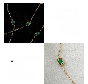Macro detail of emerald zircon pendant on an 18K gold plated titanium steel chain