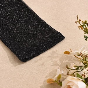 Gros plan sur un tricot noir métallisé avec paillettes argentées et texture fine