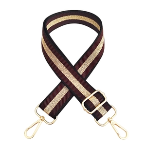 Close-up of adjustable striped handbag strap in burgundy with gold metal buckles