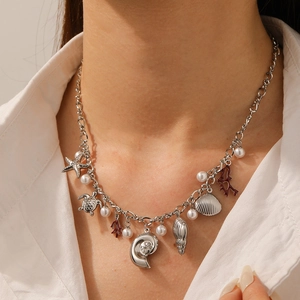 Detail of silver chain necklace with starfish shell charms and white pearls on a model