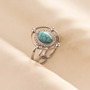 Detail of vintage silver ring featuring oval turquoise stone and openwork band