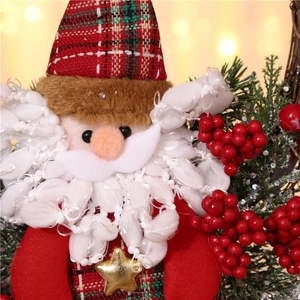 Detail of Santa plush decor with red plaid hat, gold stars, and festive pine needles