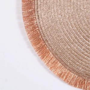 Rose gold round woven placemat with elegant tassel edges and metallic spiral texture