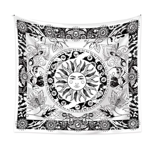Detail of bohemian tapestry featuring sun and zodiac symbols in black and white tones